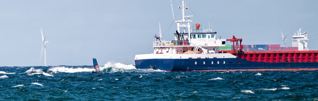 Windsurfer vor einem Schiff auf der Ostsee